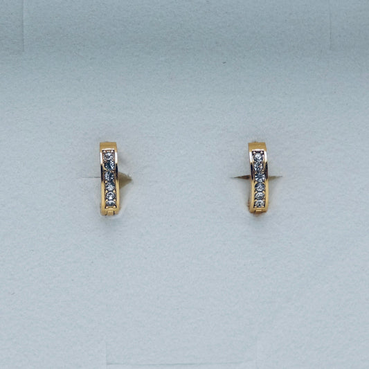 Pair of gold hoop earrings with embedded stones on a light gray background. Water proof Jewellery. Gym jewellery